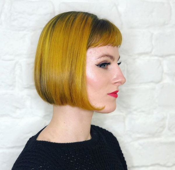 Sleek & Colored Retro Wedge Haircut with Curled Ends and Baby Bangs
