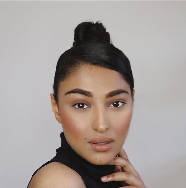 Sleek top knot with side-parted bangs