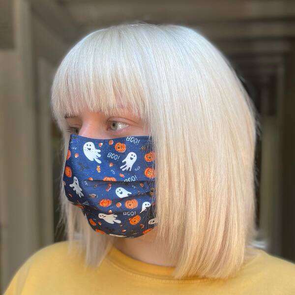 Classy Short Blonde Bob Style - a woman wearing a Halloween printed mask.