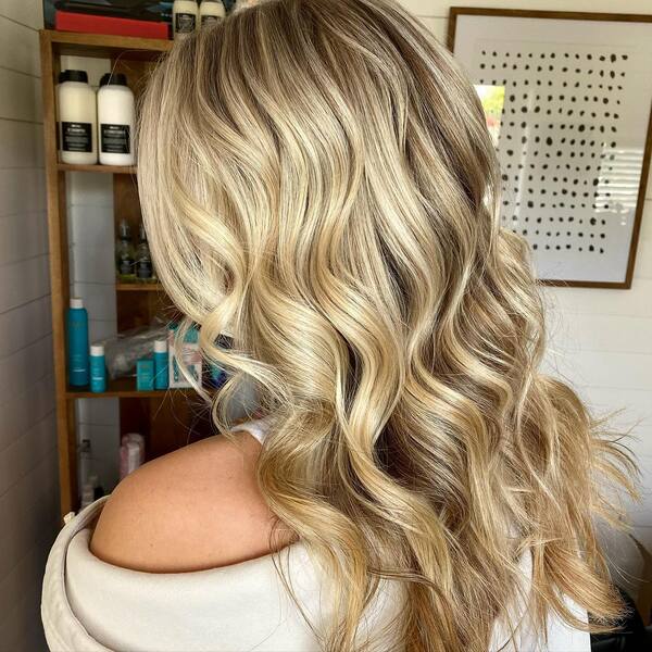 Long Curly Platinum Hair- a girl wearing an off-shoulder top.