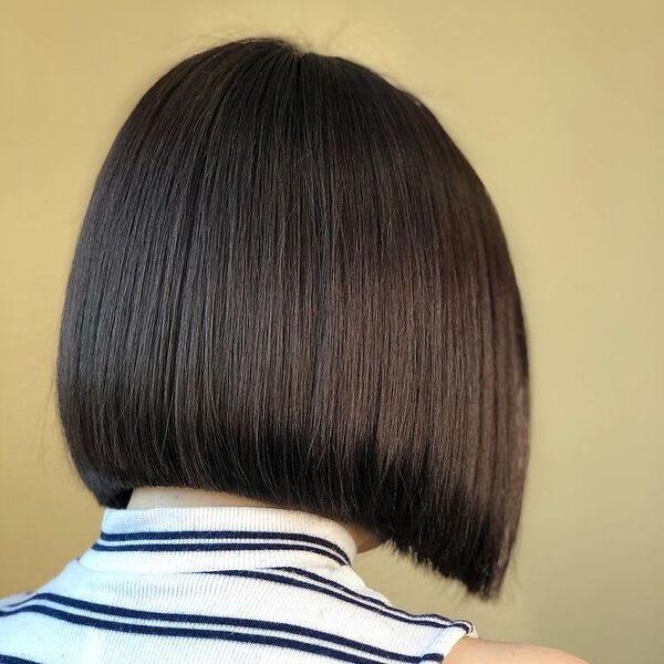 Rounded Back Blunt Haircut- a lady wearing a stripe white top.