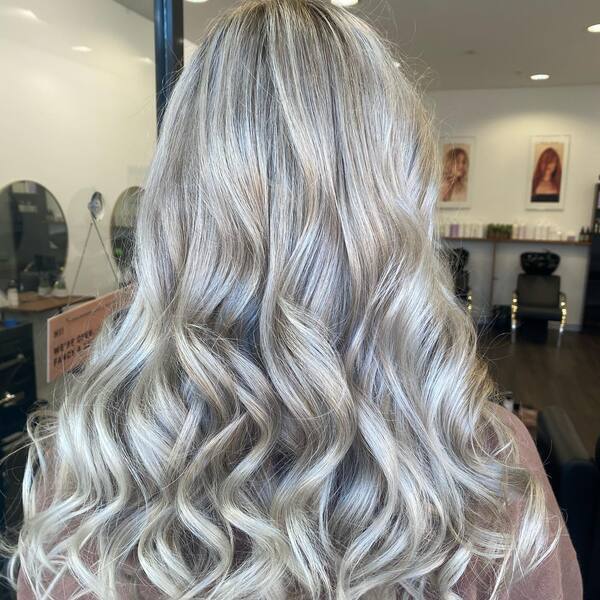 Soft Curly Platinum Style - a woman inside a room.