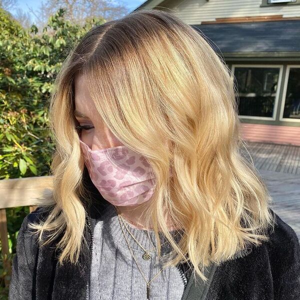 Textured Bob Haircut- a woman wearing a pink facemask.