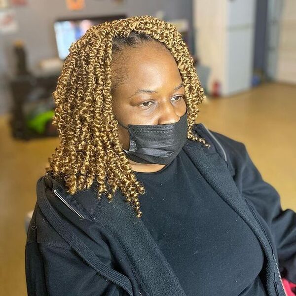 Bob-Length Curly Twists with Blonde - a woman with black facemask wearing a black jacket