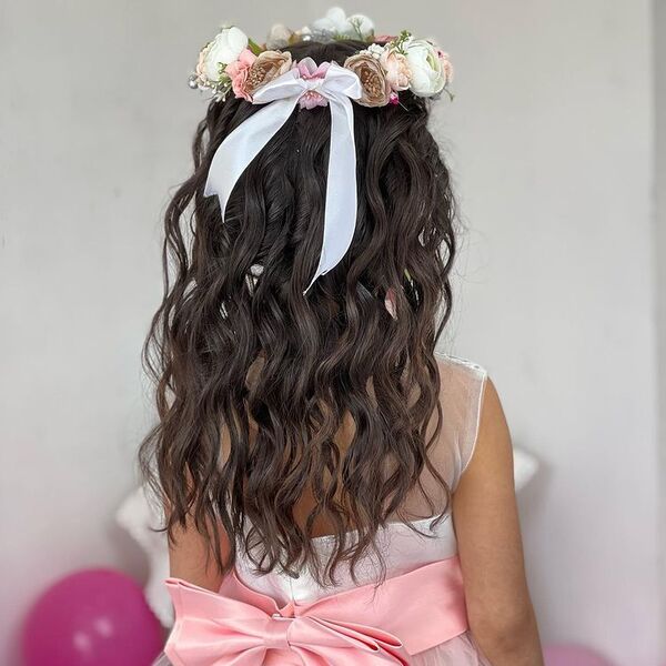 Curly Flower Girl Hairstyles with Flower Crown - a woman wearing a white see through dress