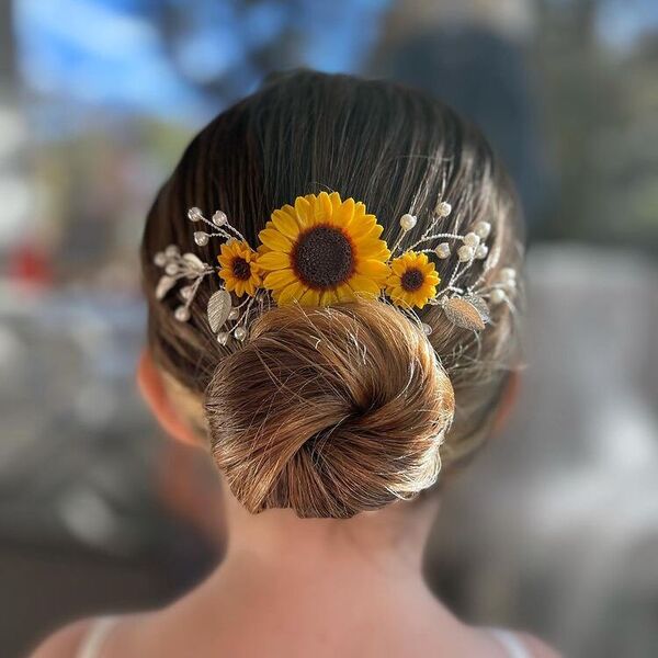 Twisted Low Bun for Flower Girl - a woman with sunflower hair decor